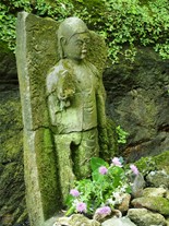 坂道の途中にある朝夷奈切通の苔生す石仏。昔から旅人を見守り続けてきたのだろうか。苔を身にまとった姿に歴史を感じる。
