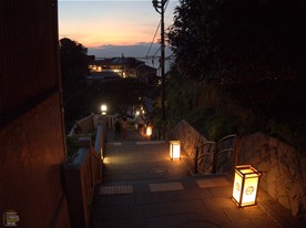 奥に見えるのは食事処「江之島亭」の建物。背後に夕日に染まる空と海。江の島独特の景色。
