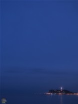 稲村ケ崎から眺める日没後の江ノ島。灯台のサーチライトに灯がともる。